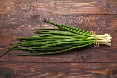 Ahşap zemin üzerinde taze soğan demeti