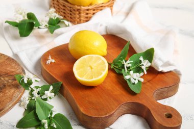 Beyaz masanın üzerinde açan dalları olan limon tahtaları.