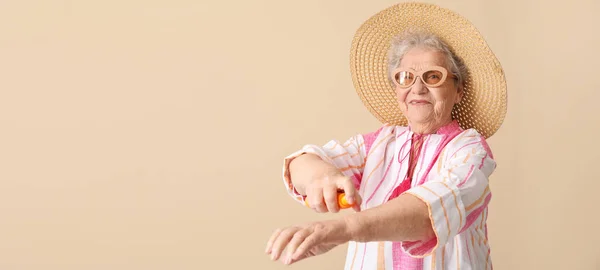 Seniorin Trägt Sonnencreme Auf Ihre Haut Vor Beigem Hintergrund Mit — Stockfoto