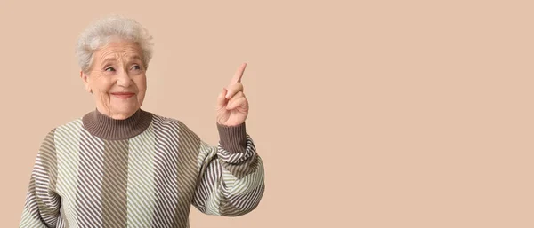 Senior Woman Pointing Something Beige Background Space Text — Stock Photo, Image