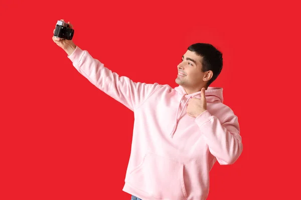 Νεαρός Άντρας Φωτογράφος Κάμερα Βγάζει Selfie Κόκκινο Φόντο — Φωτογραφία Αρχείου