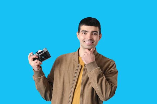 年轻男性摄影师 带着蓝色背景的复古相机 — 图库照片