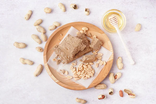 Wooden Plate Pieces Tasty Halva Peanuts White Background — Stock Photo, Image