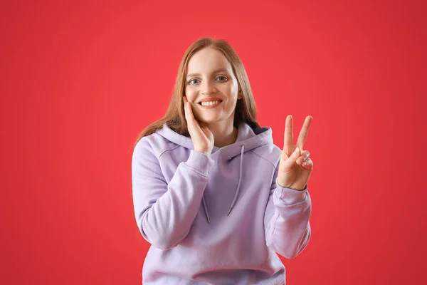 Beautiful Redhead Woman Hoodie Showing Victory Gesture Red Background — Stock Photo, Image