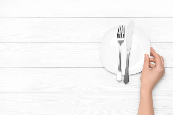 Female Hand Empty Plate Cutlery White Wooden Background — Stock Photo, Image