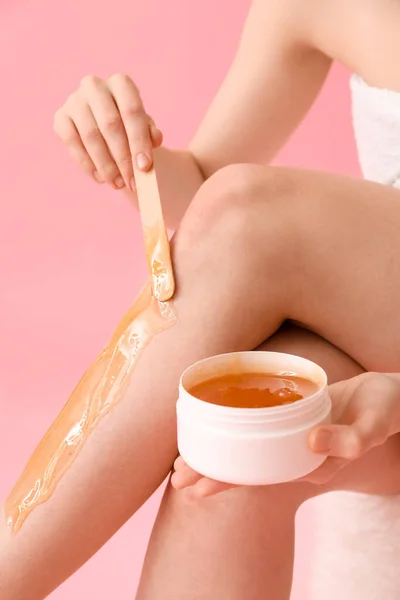 Jonge Vrouw Aanbrengen Suiker Pasta Haar Benen Tegen Roze Achtergrond — Stockfoto