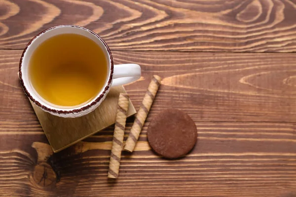 木製のテーブルの上にお茶 ウェーハロールとクッキーのカップとドリンクコースター — ストック写真