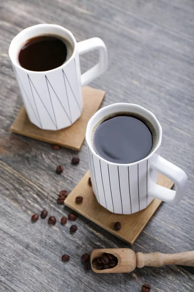 Untersetzer Mit Tassen Kaffee Und Bohnen Auf Holztisch — Stockfoto