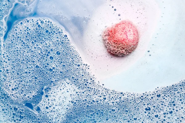 粉红浴弹在蓝水中溶解 — 图库照片