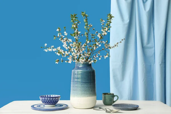 Ваза Гілками Квітучого Дерева Посудом Білому Столі Синьому Фоні — стокове фото