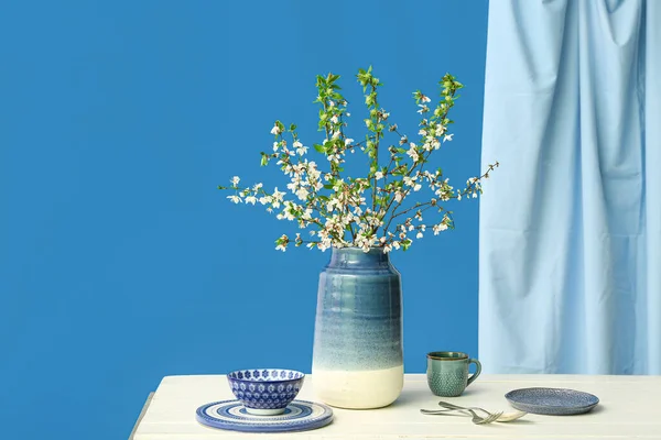 Ваза Гілками Квітучого Дерева Посудом Білому Столі Синьому Фоні — стокове фото