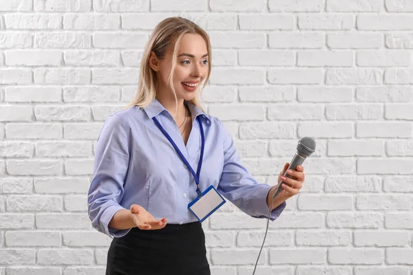 Vrouwelijke Journaliste Met Microfoon Witte Bakstenen Achtergrond — Stockfoto
