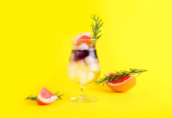 带柚子和迷迭香的紫色杜松子酒和补品杯 黄色底色 — 图库照片