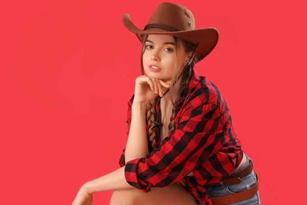 stock image Young cowgirl on red background