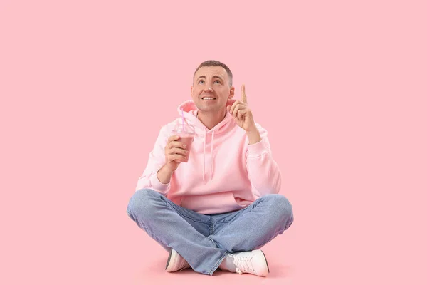 Volwassen Man Met Glas Fruit Smoothie Wijzend Iets Roze Achtergrond — Stockfoto