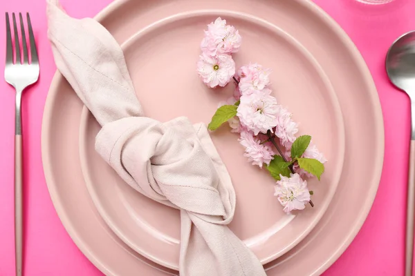 カトラリー 開花木の枝とピンクの背景に折り畳まれたナプキンを提供する美しいテーブル — ストック写真