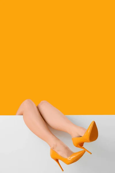 Sarı Arka Planda Şık Topuklu Kadın Bacakları — Stok fotoğraf