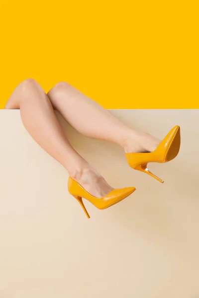 Patas Femeninas Tacones Altos Con Estilo Sobre Fondo Amarillo — Foto de Stock