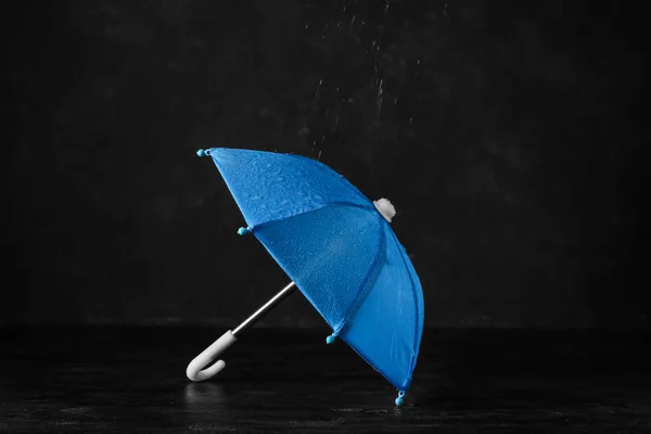 黒い背景に水滴付きミニ青い傘 — ストック写真
