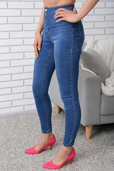 Mujer Joven Jeans Elegantes Sofá Cerca Pared Ladrillo Claro Habitación —  Fotos de Stock