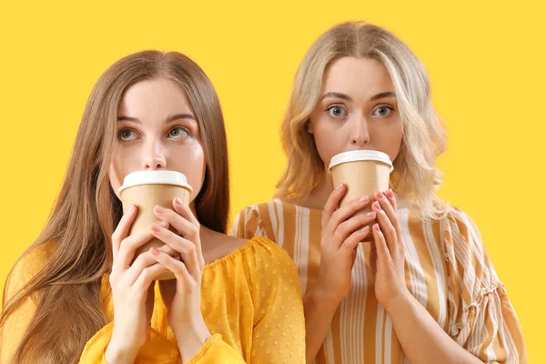 Jovens Irmãs Bebendo Café Fundo Amarelo Close — Fotografia de Stock