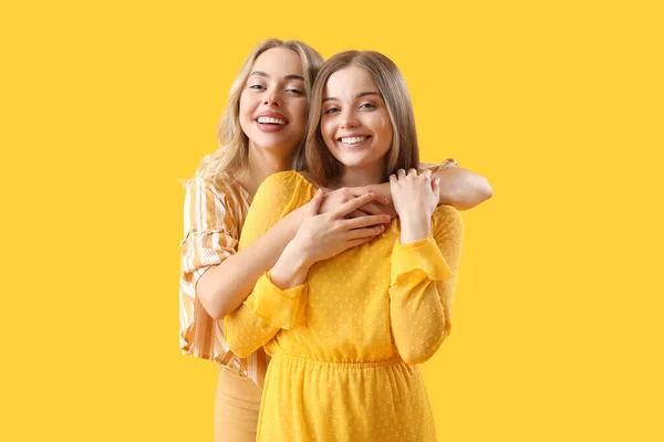Młode Siostry Przytulające Się Żółtym Tle — Zdjęcie stockowe