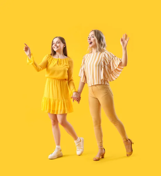 Junge Schwestern Halten Händchen Auf Gelbem Hintergrund — Stockfoto