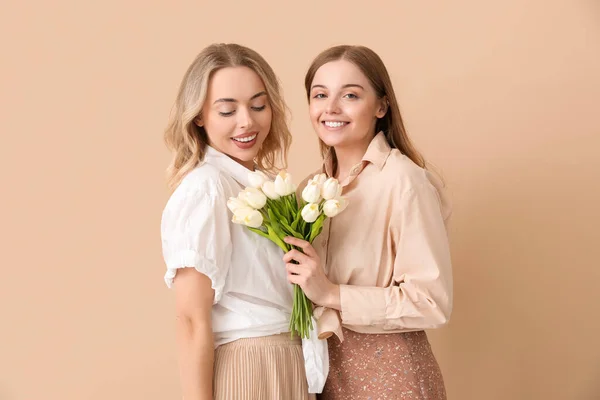 Junge Schwestern Mit Tulpen Auf Beigem Hintergrund — Stockfoto
