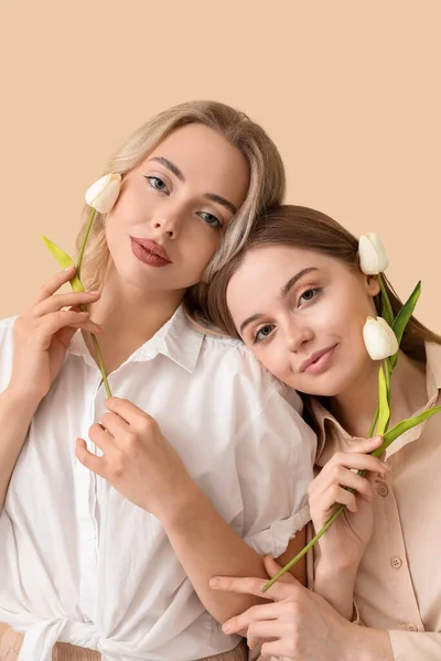 Junge Schwestern Mit Tulpen Auf Beigem Hintergrund Nahaufnahme — Stockfoto