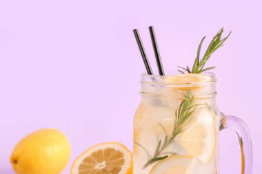 Leylak arkaplanlı limonatalı Mason kavanozu.