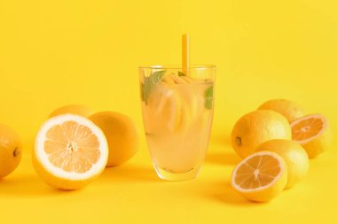Taze limonata ve sarı arka planda limonlar.