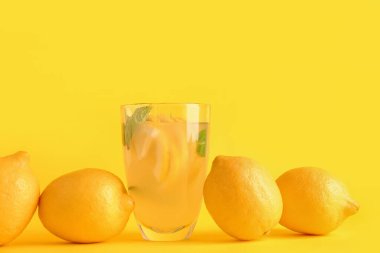 Taze limonata ve sarı arka planda limonlar.