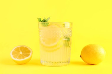 Taze limonata ve sarı arka planda limonlar.