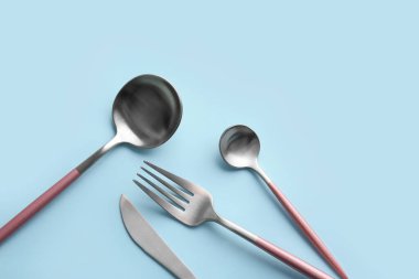 Mavi arkaplanda şık çatal bıçak takımı