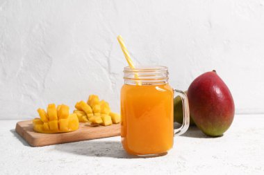 Mason kavanozu hafif arka planda taze mango smoothie.