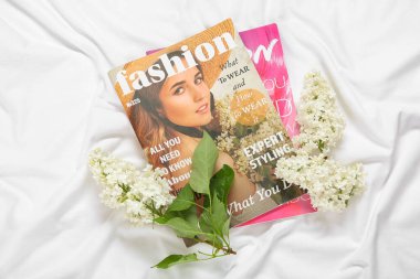 Yatağında dergiler olan güzel leylak çiçekleri.