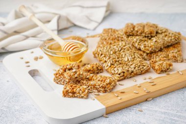 Lezzetli kozinakili ahşap tahta tahta ve beyaz grunge arka planda bal kasesi