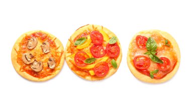 Beyaz arka planda farklı lezzetli mini pizzalar.