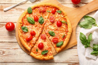 Beyaz ahşap arka planda lezzetli pizza margaritası olan bir pano.
