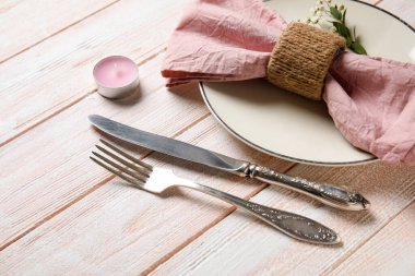 Mum ve çigila çiçekli güzel masa ayarları. Renkli ahşap arka plan, yakın plan.