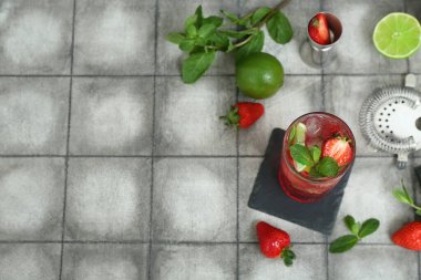 Fayans zemininde bir bardak taze çilekli mojito.