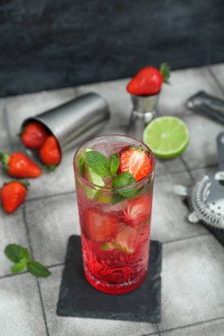 Fayans masasında bir bardak taze çilekli mojito.