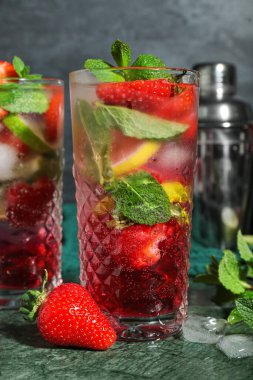 Koyu arkaplanda lezzetli çilekli mojito bardakları, yakın plan.