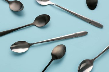 Mavi arka planda paslanmaz çelik kaşıklar