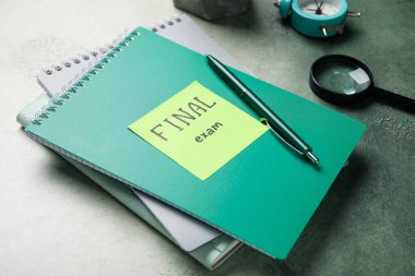 Yazılı yapışkan not FINAL Sınav Defteri, not defterleri, büyüteç ve grunge arkaplan üzerindeki alarm saati