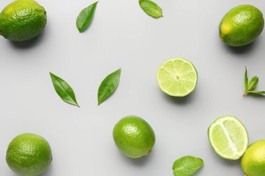 Gri arkaplanda yaprakları olan taze limonlar