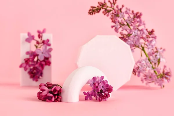 Lilac flowers with plastic figures on pink background