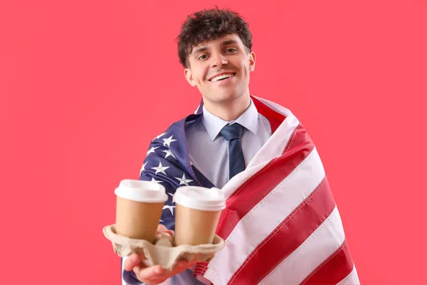 stock image Male businessman with USA flag and cups of coffee on red background