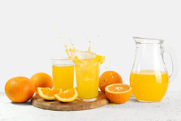 Jug Glasses Fresh Orange Juice Splashes White Background — Stock Photo, Image