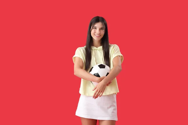 Mladá Žena Fotbalovým Míčem Červeném Pozadí — Stock fotografie